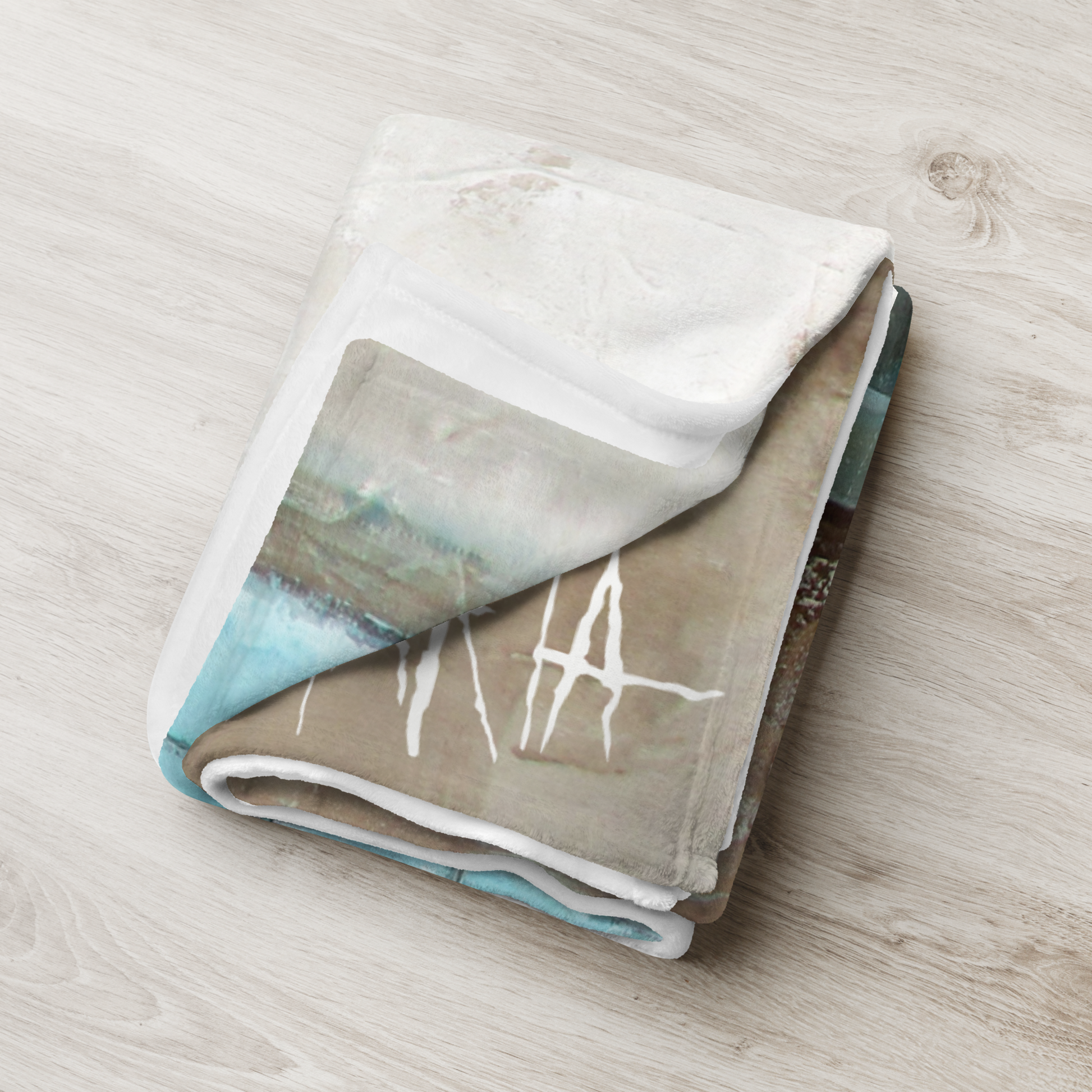 Folded blanket with artistic design on a wooden surface