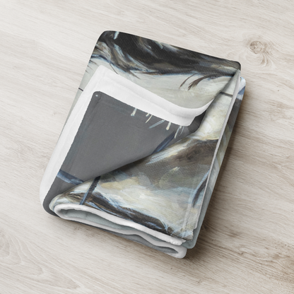 Folded blanket with abstract pattern on a wooden surface