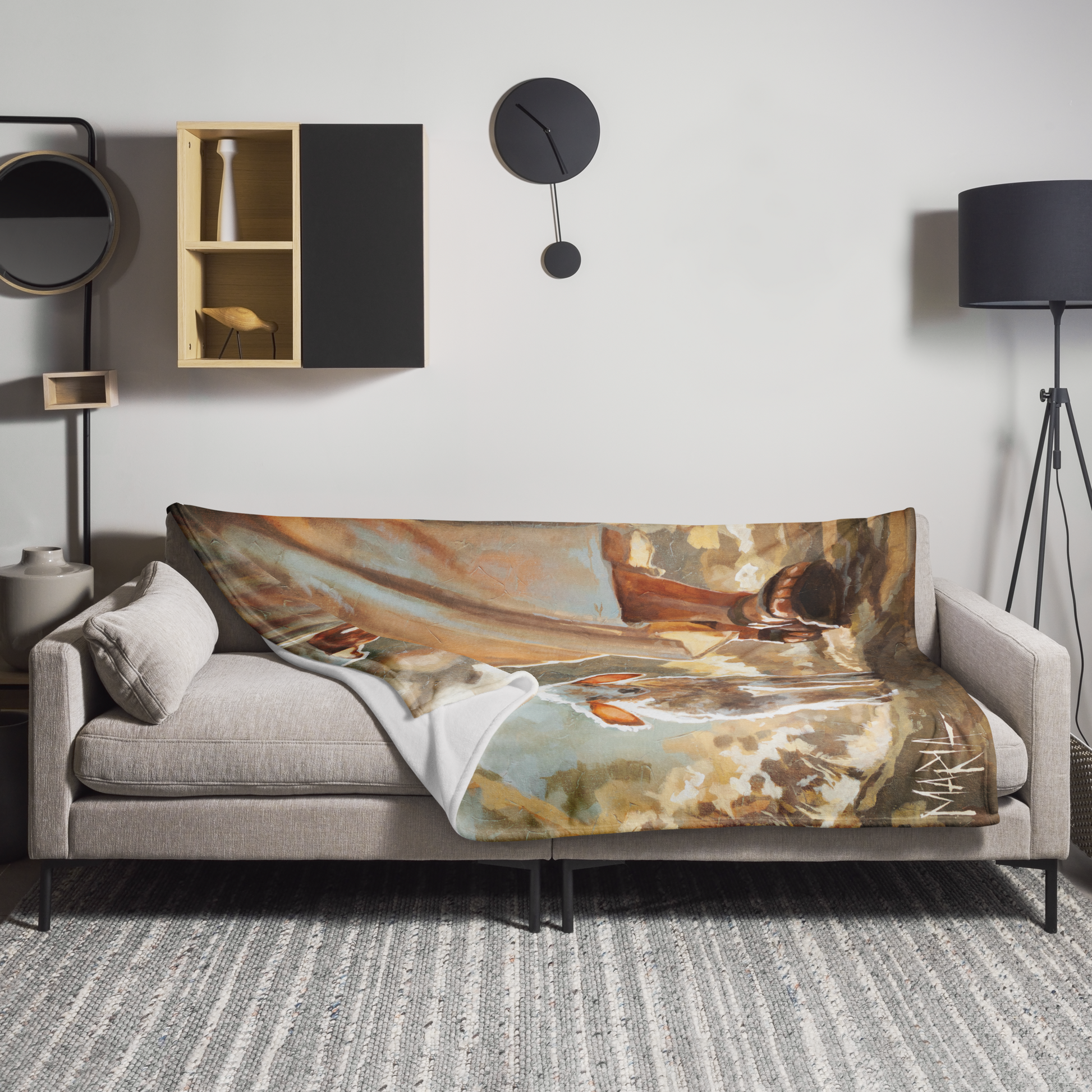 Sofa with a decorative blanket featuring artistic design in a modern living room.
